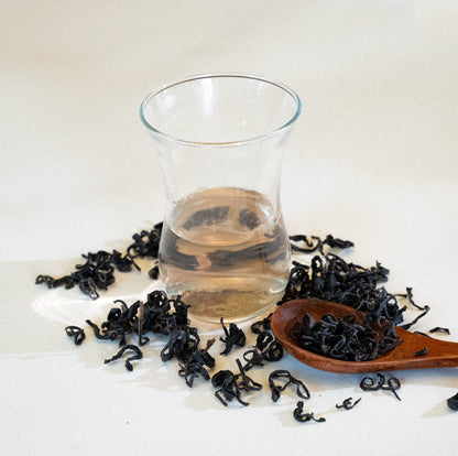 Thé violet rare du Kenya aux feuilles naturellement pourpres, cultivé bio et équitable en méthodes traditionnelles. Produit artisanal en vrac de 80g, récolté à la main sur les hauts plateaux kenyans. Feuilles entières aux notes douces et terreuses avec des accents floraux et herbacés mystérieux. Riche en antioxydants, ce thé offre une stimulation douce et renforce l'immunité. Goût fruité et profondeur élégante rappelant les forêts africaines. 